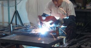 Laser cutting machine cutting metal with sparks flying at Leaderseating factory.